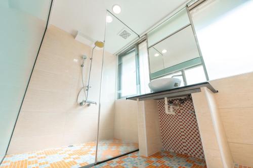 台中市台中灣文旅 T C ONE Hotel的一间带玻璃淋浴间和水槽的浴室