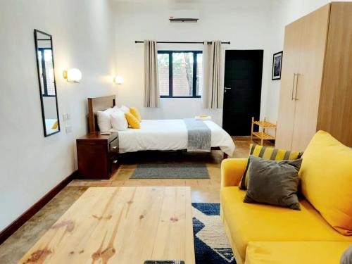 布兰太尔Instahomes by Tru - Mt Pleasant Apartments的一间卧室配有一张床和一张黄色的沙发