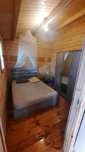 圣菲利普Chalet de la Mer Cassée的小木屋内一间卧室,配有一张床