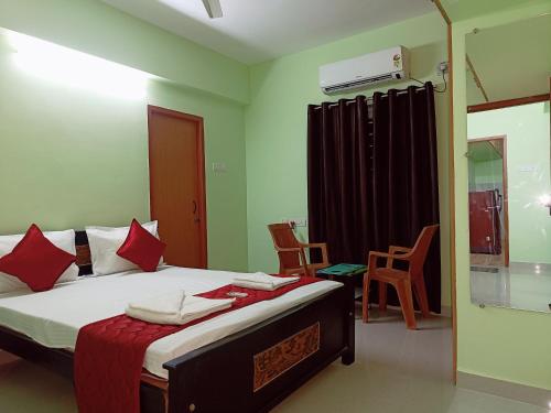 钦奈Ananya service apartments的一间卧室配有红色枕头的床