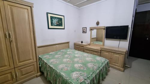 雅加达WKNDR Zone的一间卧室配有一张床、镜子和电视