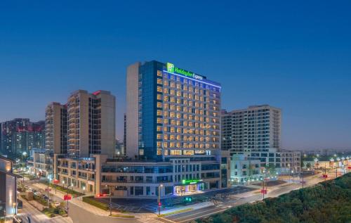 绵阳绵阳科技城智选假日酒店的城市的一座有灯光的建筑