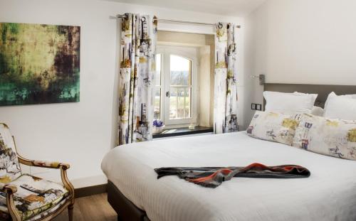 格里尼昂La Ferme Chapouton - Teritoria的卧室配有床、椅子和窗户。