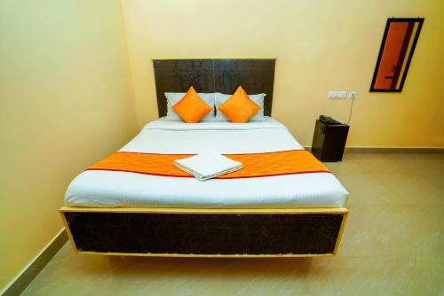 蒂鲁帕蒂Ssunshhine residency (NEW)的一间卧室配有橙色和白色床单。