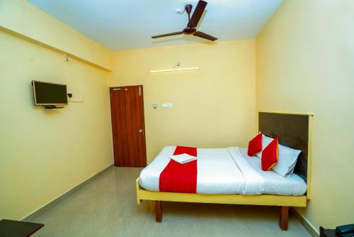蒂鲁帕蒂Ssunshhine residency (NEW)的一间卧室配有红色和白色枕头的床