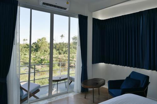 Bang KrasopGreen Lung Pool Villas Bangkok的酒店客房设有一张床和一个大窗户
