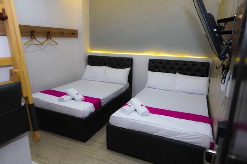 马尼拉OYO 1030 Ai Hotel的小型客房 - 带两张床垫