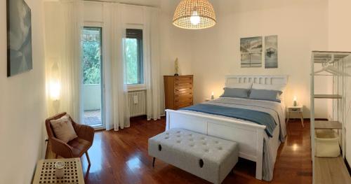 帕多瓦A casa di cocco的一间卧室配有一张床、一把椅子和窗户。