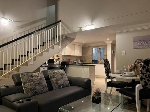 比勒陀利亚Executive suite@Lofts的带沙发和桌子的客厅以及厨房。