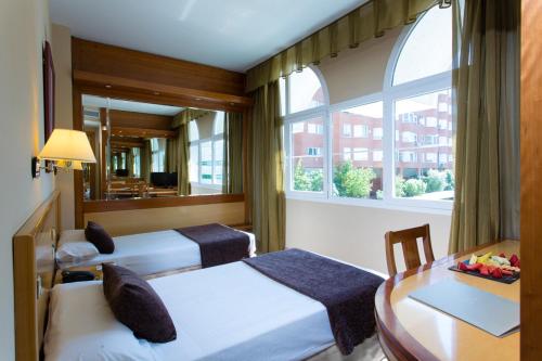 特雷斯坎多斯VP特雷斯坎托斯花园酒店的客房设有两张床、一张桌子和一扇窗户。