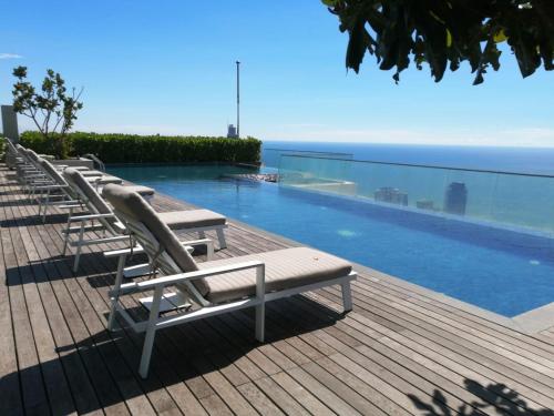 科伦坡Altair Luxury Colombo by Miracle的游泳池旁的一排躺椅