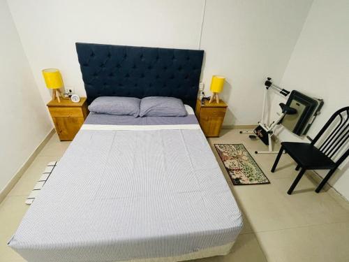 科尔多瓦bedroom and private bathroom Habitacion y baño privado - en una casa的卧室配有一张白色大床和一把椅子
