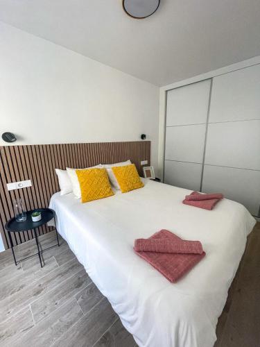 格拉纳达H&H Suite El Mirlo的卧室配有带毛巾的大型白色床