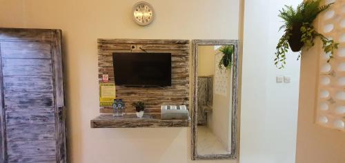 NegaraAna homestay的挂在墙上的镜子,上面有电视