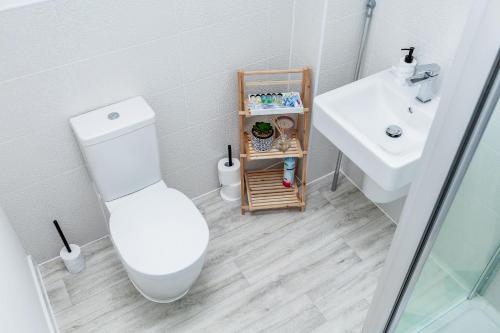 曼彻斯特Beautifully Fab 3 bedroom 4 beds New home 8 guests Stretford Trafford的白色的浴室设有卫生间和水槽。