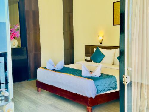甘托克Tara Palace Resort and SPA的一间卧室配有一张带蓝白色枕头的大床