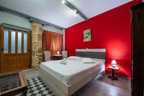 塞尼梅西奇卡罗Ξενώνας Ηχώ的红色的卧室,配有一张床和红色的墙壁