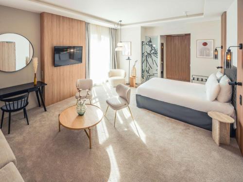 特鲁瓦特鲁瓦中心美居酒店的配有一张大床和一架钢琴的酒店客房