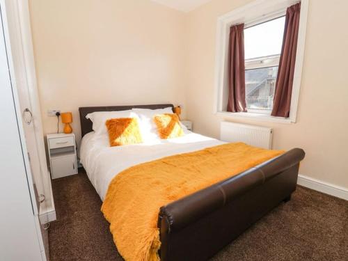布里德灵顿Stella’s secret的一间卧室配有带橙色枕头的床和窗户。