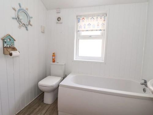 布里德灵顿Stella’s secret的一间带卫生间和浴缸的浴室以及窗户。