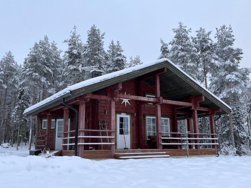 SonkaKenttäniemi Cottages的雪中小木屋,有树