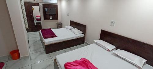 乌贾因Hotel Shri Krishna Palace的一间卧室配有两张床和镜子