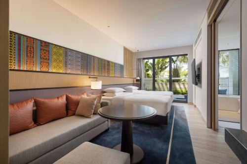 三亚三亚天丽湾凯悦酒店的酒店客房设有两张床、一张沙发和一张桌子。