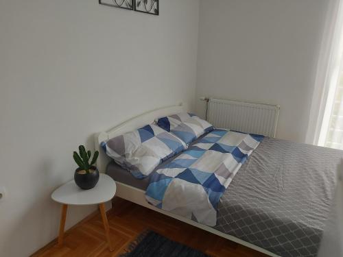 诺维萨德Nikola NS的一间卧室配有一张床和一张带盆栽的桌子