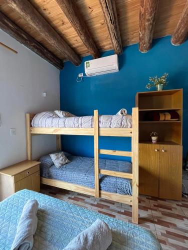 Las HerasMonoambiente lo de Carola Mendoza的蓝色墙壁的客房内设有两张双层床。