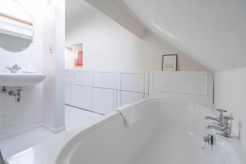 安特卫普The Handshake House的白色的浴室设有浴缸和水槽。