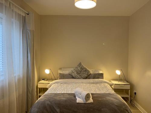 莱特肯尼Letterkenny Three Bedroom Town Centre Apartment的一间卧室配有一张床,床上有毛巾