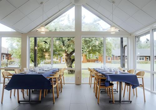 林雪平Valla Folkhögskola的一间设有蓝色桌椅和窗户的用餐室