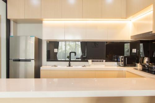 暹粒Sky Park Condotel & Residence的厨房配有白色橱柜和不锈钢冰箱
