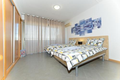 波尔蒂芒Ruby Red & Atlantic Blue Apartments in Oceano Atlantico的一间卧室设有一张大床和一个窗户。