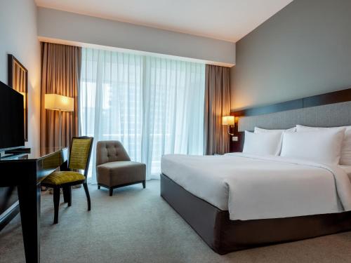 迪拜Flora Creek Deluxe Hotel Apartments, Deira的酒店客房配有一张床、一张桌子和一把椅子。