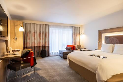 梅赫伦梅赫伦中心诺富特酒店的酒店客房设有一张大床和一张沙发。
