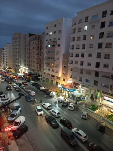 艾尔亚奈Joli studio, 17 Avenue Hedi Nouira Ennasr 2, Ariana, Tunis的一条城市街道,有汽车停在停车场