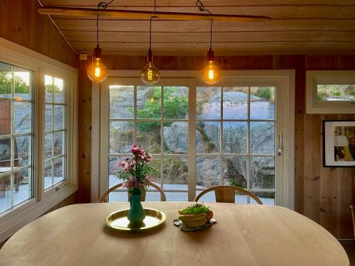 利勒桑Idyllic Cabin in Lillesand fantastic ocean view的用餐室,配有花瓶桌子