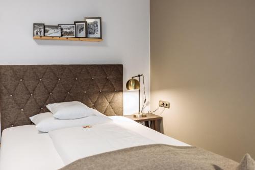 海利根布卢特大格洛克纳山国家公园酒店的卧室配有白色的床和床头板