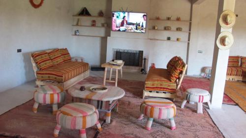 马拉喀什Family Village Marrakech的客厅配有沙发、椅子和电视