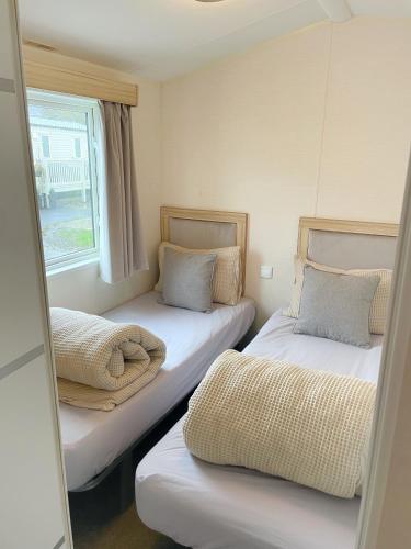 布莱克浦3 bedroom luxury caravan haven, marton mere的小型客房 - 带2张床和窗户