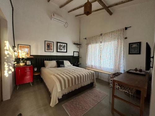 普拉杜Casa Chão的一间卧室配有一张床、一张书桌和一个窗户。