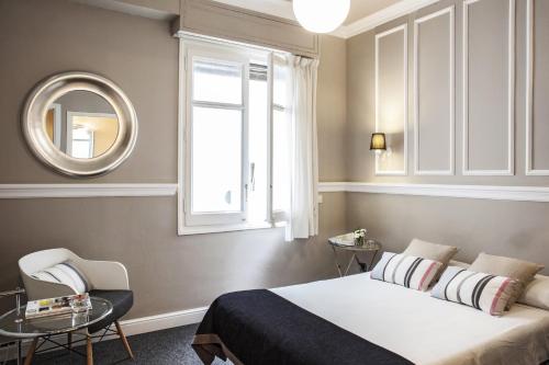 巴塞罗那恩艾克蒙塔纳酒店的一间卧室设有一张床、一个窗口和一面镜子