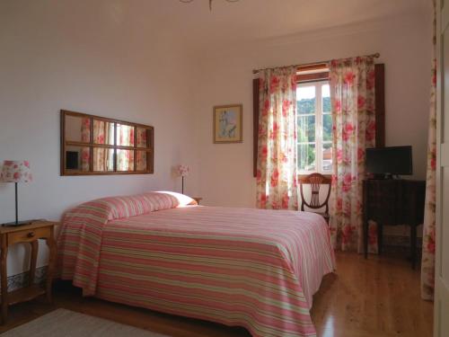 辛特拉Casa da Villa 1A的一间卧室配有一张带条纹毯子的床和窗户