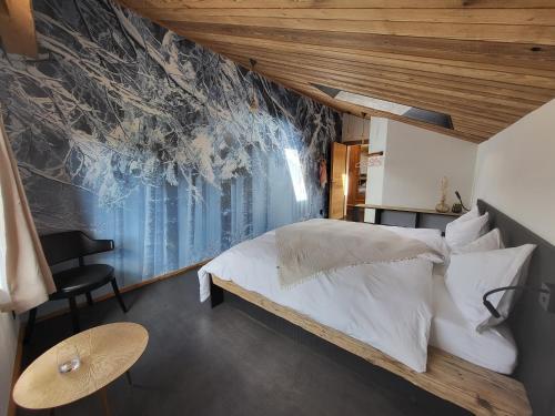 La SagneHôtel-Restaurant Le Cochon Rose的一间卧室配有一张床和壁画墙