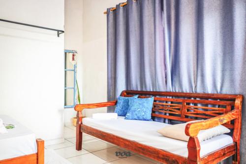 Bairro da EnseadaPousada Aconchego Recanto Canto Do Mar的一间卧室配有一张带蓝色枕头的木床。