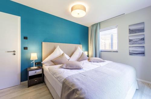 欧巴德伍斯图Seeluft an der Ostsee的一间卧室设有一张蓝色墙壁的大床