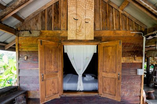 素可泰Suk Sabai Homestay的木柜内的一张床位,配有窗帘
