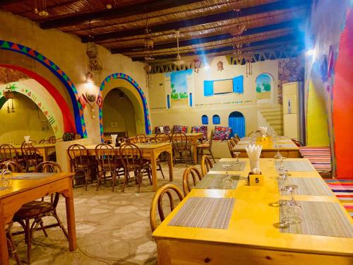 阿布辛贝Kabara Nubian House的一间带木桌和椅子以及彩虹的餐厅