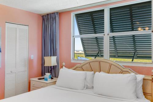 基韦斯特Sunrise Suites - Saint Kitts 412的卧室拥有粉红色的墙壁,配有一张带白色枕头的床